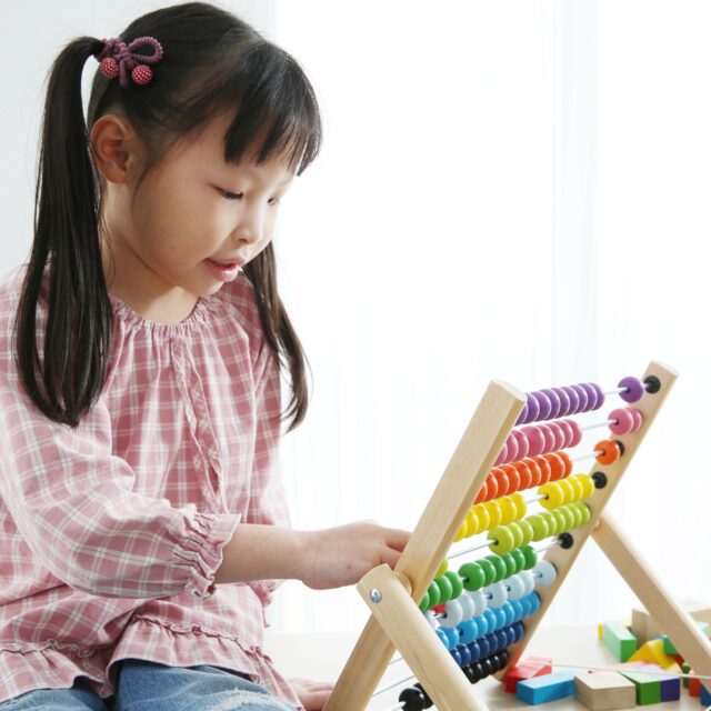 Brain Development At Early Childhood With The Abacus. kindergarten children with colorful wooden abacus. Child’s ability concept ,Educational toy